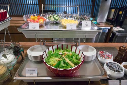 a buffet with a salad in a bowl on a tray at Dormy Inn Toyama Natural Hot Spring in Toyama