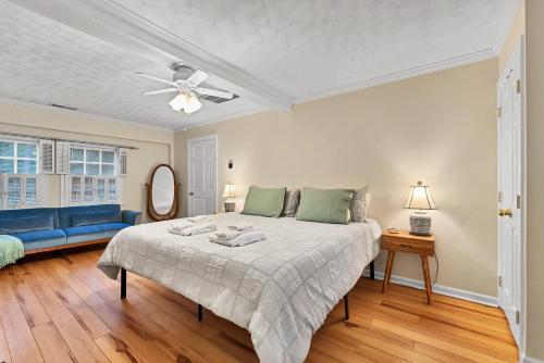 une chambre avec un lit et un canapé bleu dans l'établissement The Cottage at Knollwood Manor, à Southern Pines