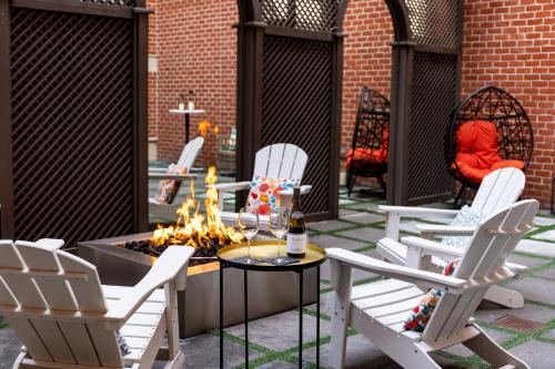 a patio with white chairs and a fire pit at Archer Hotel Old Town Alexandria in Alexandria