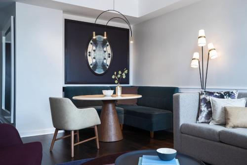 a living room with a table and a couch at Archer Hotel Old Town Alexandria in Alexandria