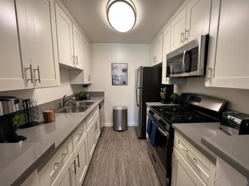 a kitchen with white cabinets and a stainless steel refrigerator at Exceptional 2 BR in Heart of Hollywood 201 in Los Angeles
