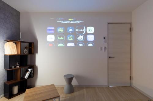 a room with a wall with a screen with iphones at Grandest living Nipponbashi 2Bedroom in Osaka