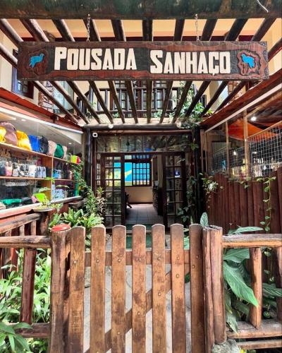 a wooden fence in front of a store with a sign at Pousada Sanhaço in Abraão
