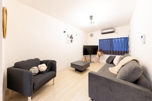 a living room with a couch and a chair at Grandest living Nipponbashi 2Bedroom in Osaka