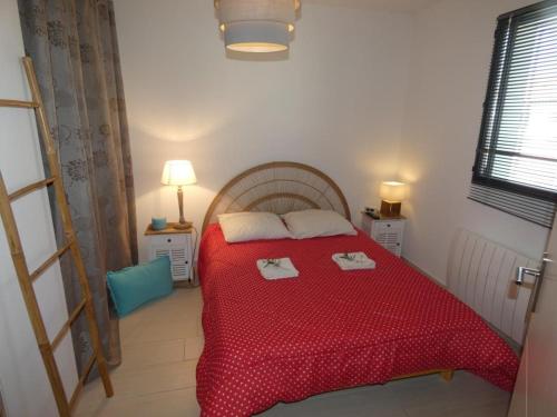 - une chambre avec un lit rouge et 2 serviettes dans l'établissement Maison spacieuse avec jardin clos, près plage, animaux OK, 10 pers, Notre-Dame-de-Monts - FR-1-540-137, à Notre-Dame-de-Monts