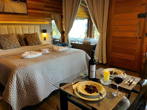 a bedroom with a bed and a table with a plate of food at Cabana Alpen Ville com Banheira - Rural in Bom Jardim da Serra