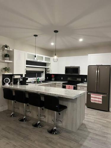 a kitchen with a large island with bar stools at Crystal's Place in Moncton