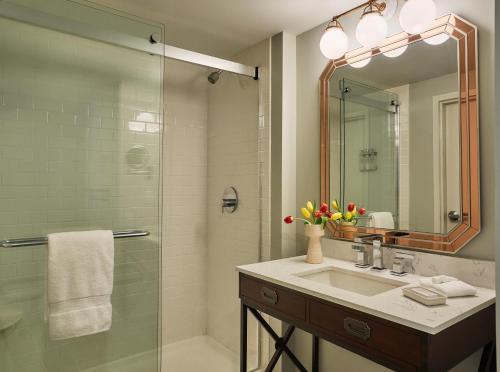 a bathroom with a sink and a shower with a mirror at Graduate Oxford in Oxford