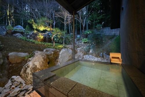 a small swimming pool in a yard with a bench at Oni no Sumika in Izu