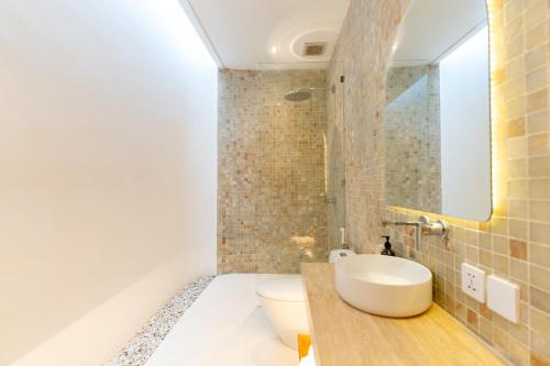 a bathroom with a white toilet and a sink at Sonnys Uluwatu in Uluwatu