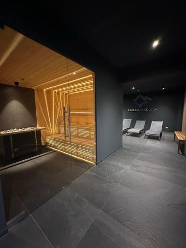 a room with a lobby with chairs and a fireplace at Apartament GÓRSKIE MAZURY w Lagunie Beskidów in Zarzecze