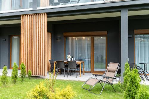a patio with a table and chairs in a yard at Apartament GÓRSKIE MAZURY w Lagunie Beskidów in Zarzecze