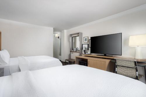 a hotel room with two beds and a flat screen tv at Holiday Inn Resort Oceanfront at Surfside Beach by IHG in Myrtle Beach