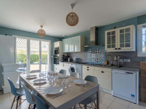 une cuisine avec une table avec des assiettes et des verres dessus dans l'établissement Maison Familiale à Gastes, 400m du Lac, Climatisée, Jardin, 6 Pers. - Ménage Inclus - FR-1-319-575, à Gastes