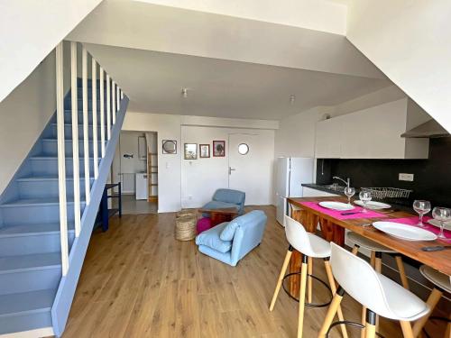 Il comprend une cuisine et un salon avec un escalier bleu. dans l'établissement **Duplex Lumineux à Deux Pas de la Plage et Commerces - Berck** - FR-1-646-76, à Berck-sur-Mer