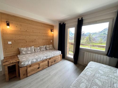 une chambre avec un lit et une grande fenêtre dans l'établissement Appartement Confort 6 pers, Skis aux Pieds, Services Inclus! - FR-1-634-101, à Morzine