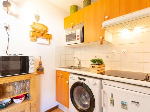 une cuisine avec un lave-linge et un micro-ondes dans l'établissement Appartement spacieux pour 6 pers. avec jardin, St-Lary-Soulan à proximité télécabine et thermes - FR-1-296-500, à Vielle-Aure