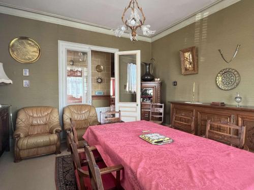 une salle à manger avec une table et des chaises roses dans l'établissement Appartement vintage à 700m de la plage avec 3 chambres à Pornichet - FR-1-392-242, à Pornichet