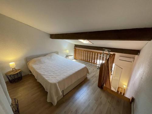 une chambre avec un grand lit et un parquet dans l'établissement Pavillon climatisé avec mezzanine, 4 couchages, proche plage et commerces, parking privé, St-Cyprien - FR-1-106-105, à Saint-Cyprien