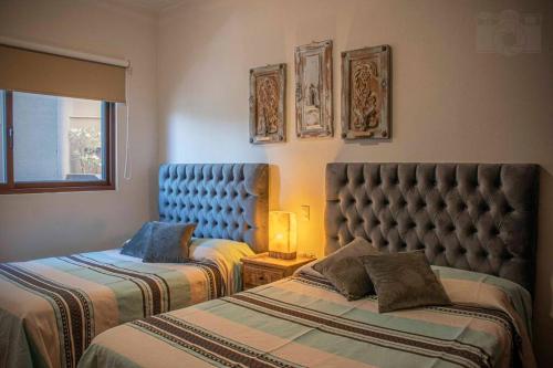 1 Schlafzimmer mit 2 Betten und einem blauen Kopfteil in der Unterkunft Lovely 3BD 4BA APT Pool Gym Parking in San Miguel de Allende