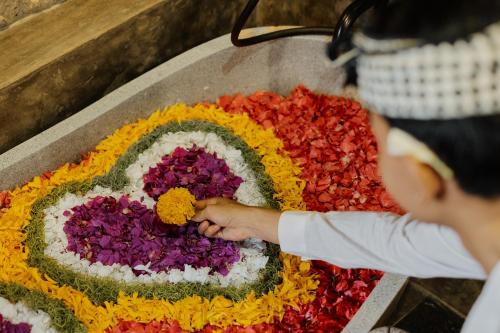 a person is arranging flowers in a table at Uddhara Ubud Villa in Ubud