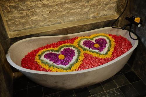 a bath tub filled with flowers in the form of hearts at Uddhara Ubud Villa in Ubud
