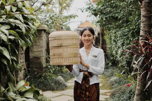 a woman holding up a large stack at Uddhara Ubud Villa in Ubud
