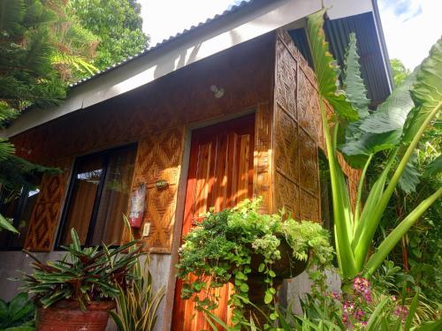 a house with plants in front of it at Hidden Tourist Inn in Mambajao