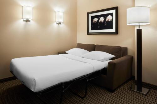 a hotel room with a bed and a lamp at Delta Hotels by Marriott Guelph Conference Centre in Guelph