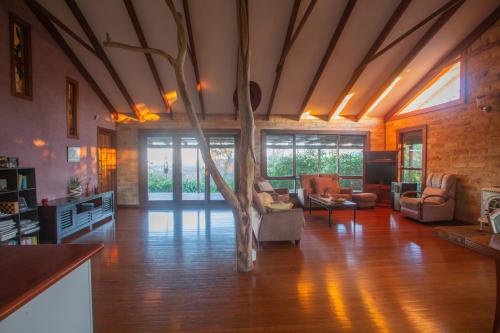 a living room with a tree in the middle of it at Stone Cottage in Possum Brush