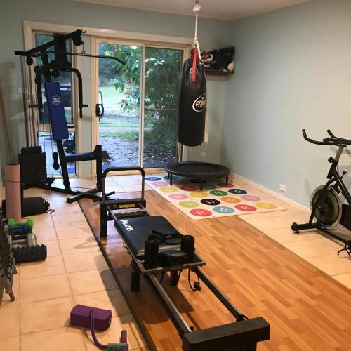 a gym with a punching bag hanging on the wall at Stone Cottage in Possum Brush