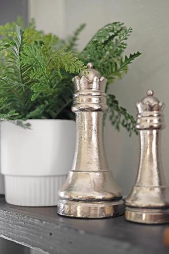 two metal chess pieces on a table next to a potted plant at Comfortable 6BR 2Bath in the heart of Niagara Falls in Niagara Falls