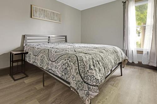 a bed in a bedroom with a blanket on it at Comfortable 6BR 2Bath in the heart of Niagara Falls in Niagara Falls