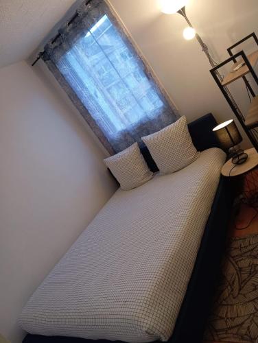 a bedroom with a bed and a window at Noxio voyages in Evry-Courcouronnes