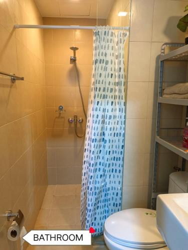 a bathroom with a shower with a blue shower curtain at Newly Opened Cozy Studio Near Airport in Iloilo City