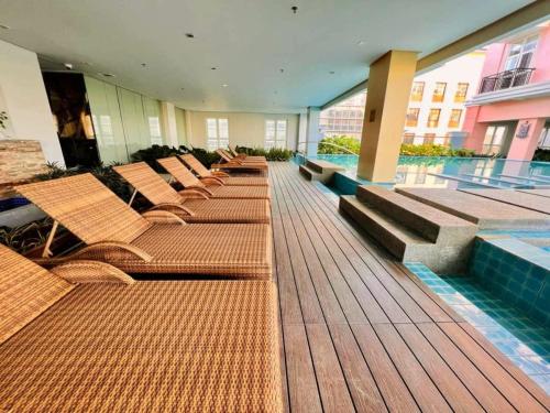 a row of chairs and a pool in a building at Newly Opened Cozy Studio Near Airport in Iloilo City