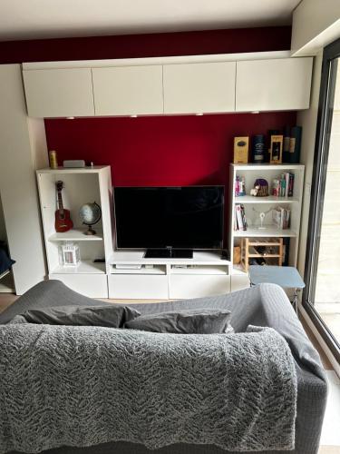un salon avec une télévision à écran plat sur un mur dans l'établissement Appartement Zen, à Bourg-la-Reine