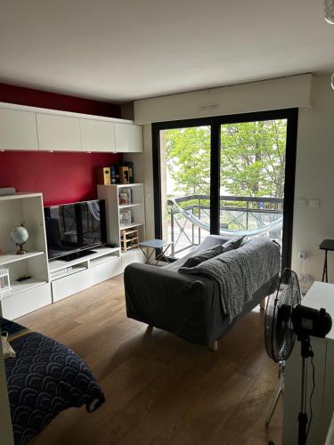 une chambre avec un lit et une grande fenêtre dans l'établissement Appartement Zen, à Bourg-la-Reine
