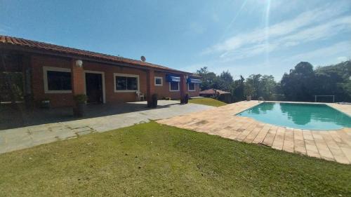 a house with a swimming pool in the yard at Casa da Felicidade in Ibiúna