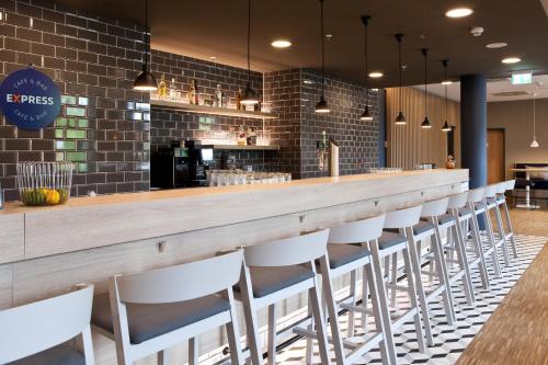 a bar with white chairs at a restaurant at Holiday Inn Express Bochum by IHG in Bochum