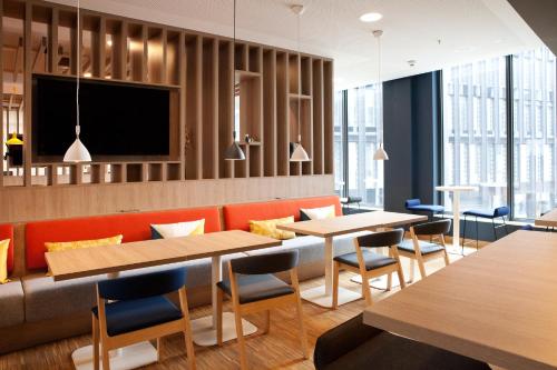 a restaurant with tables and chairs and a tv at Holiday Inn Express Bochum by IHG in Bochum