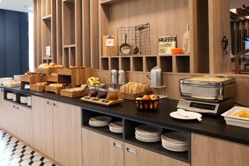 a kitchen with a counter with plates and food at Holiday Inn Express Bochum by IHG in Bochum
