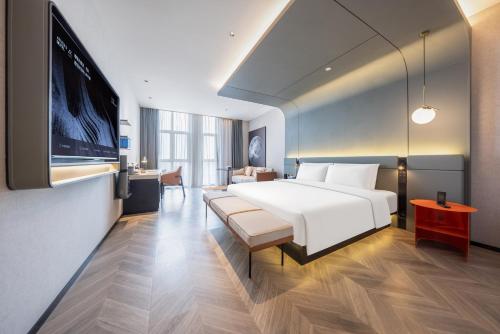 a hotel room with a bed and a flat screen tv at Atour S Hotel Hefei Innovation Industrial Park Wangjiang West Road in Hefei