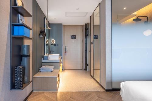 a room with a bed and a bathroom with a sink at Atour S Hotel Hefei Innovation Industrial Park Wangjiang West Road in Hefei