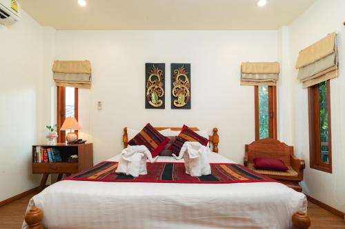ein Schlafzimmer mit einem Bett mit Handtüchern für 2 Personen in der Unterkunft Gordnuea Boutique House in Chiang Mai