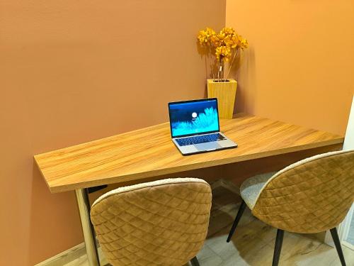 a laptop computer sitting on a wooden table with two chairs at Republica del Salvador Coliving Ecuador XOE in Quito