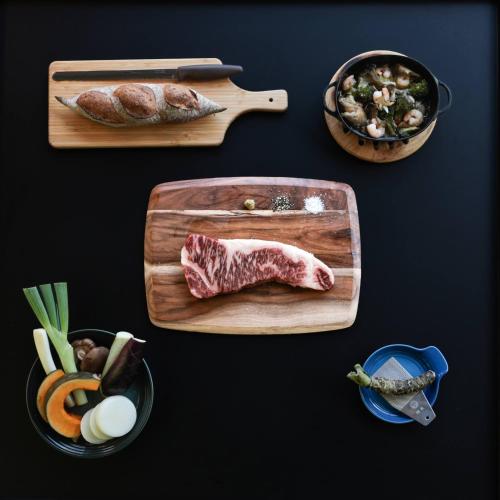 a table topped with cutting boards with meat and vegetables at Landscape Hotel THEATER 1 in Hinohara