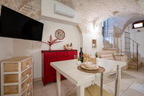 a living room with a table and a tv at Trulli Contento - Rooms & Apartments in Alberobello