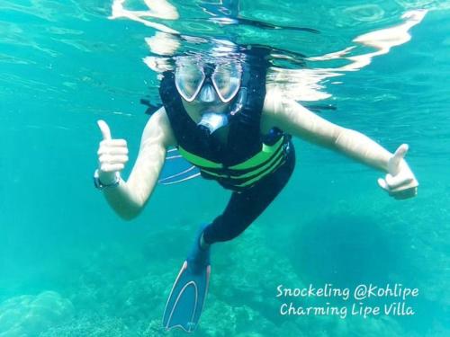 a woman in the water giving a thumbs up at Charming Lipe Beach Resort in Ko Lipe