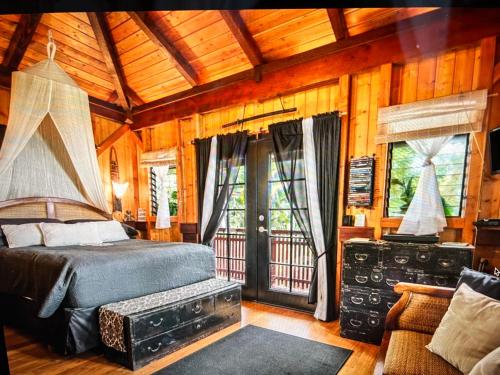 a bedroom with a bed in a room with wooden walls at The Bali House and Cottage at Kehena Beach Hawaii in Kehena